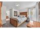 Cozy bedroom with a wooden bed frame, side tables, and soft natural light from the window at 15206 Merlinpark Pl, Lithia, FL 33547