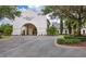 Palmetto Club entryway with manicured landscaping, and well-maintained circular driveway at 15206 Merlinpark Pl, Lithia, FL 33547
