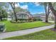 Beautifully landscaped front yard with a well-maintained lawn and charming architectural details at 15206 Merlinpark Pl, Lithia, FL 33547