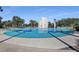 Community water fountain set in a large concrete area, with shade trees around the fountain at 15206 Merlinpark Pl, Lithia, FL 33547