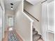 Inviting hallway featuring a staircase and an open doorway leading to a sunny room at 15206 Merlinpark Pl, Lithia, FL 33547
