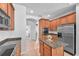 Traditional kitchen with wood cabinets, an island with granite countertop, and stainless steel appliances at 15206 Merlinpark Pl, Lithia, FL 33547