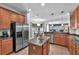 Open kitchen featuring stainless steel appliances, granite countertops, and an island with views of the eat-in kitchen at 15206 Merlinpark Pl, Lithia, FL 33547