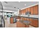 Open kitchen featuring wood cabinets, granite countertops, stainless steel appliances, and an island at 15206 Merlinpark Pl, Lithia, FL 33547