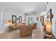 Bright living room with neutral furniture, tile flooring, and natural light from a glass slider at 15206 Merlinpark Pl, Lithia, FL 33547