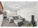 Comfortable living room featuring a gray sofa, ottoman, TV, and natural light at 15206 Merlinpark Pl, Lithia, FL 33547