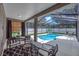 Backyard pool with screened enclosure, seating area and lush greenery at 15206 Merlinpark Pl, Lithia, FL 33547