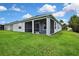 Rear view of the home, highlighting a screened patio area and lush green lawn at 1846 Moorhen Way, Lutz, FL 33558