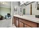 Modern bathroom featuring a wood vanity with white countertop, ample storage, and stylish fixtures, adjacent to the office space at 1846 Moorhen Way, Lutz, FL 33558