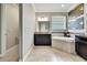 Bright bathroom featuring a soaking tub, dark wood cabinets, and decorative geometric artwork at 1846 Moorhen Way, Lutz, FL 33558