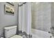 Bathroom features a white toilet, bathtub, and tiled walls, creating a clean and stylish area at 1846 Moorhen Way, Lutz, FL 33558