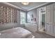 Bright bedroom with modern white furniture, a window with floral accents, and a door to a hallway at 1846 Moorhen Way, Lutz, FL 33558