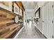 Hallway with decorative wood accent wall, tile floors, and a view towards the living area at 1846 Moorhen Way, Lutz, FL 33558