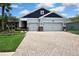 Charming home featuring a wide driveway, lush landscaping, and a neutral color scheme at 1846 Moorhen Way, Lutz, FL 33558