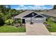 Beautiful one story home with a manicured lawn, lush landscaping, and a brick paver driveway at 1846 Moorhen Way, Lutz, FL 33558