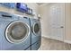 Laundry room with blue washer and dryer at 1846 Moorhen Way, Lutz, FL 33558