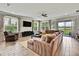 Living room featuring a comfy sectional sofa, a TV, and large windows at 1846 Moorhen Way, Lutz, FL 33558