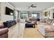 Living room featuring a comfy sectional sofa, a TV, and large windows at 1846 Moorhen Way, Lutz, FL 33558