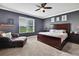 Bedroom with a large window, ceiling fan, and dark brown furniture at 1846 Moorhen Way, Lutz, FL 33558