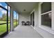The screened patio features a pair of chairs and a view of the fenced in lawn at 1846 Moorhen Way, Lutz, FL 33558