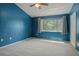 Spacious bedroom with blue walls, plush carpeting, and a large window at 2314 Lake Woodberry Cir, Brandon, FL 33510