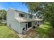 Exterior rear view of a multi-story home with a patio, lawn, and large trees at 2314 Lake Woodberry Cir, Brandon, FL 33510