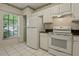 Bright kitchen featuring white appliances, tile floors, and views of the outdoors at 2314 Lake Woodberry Cir, Brandon, FL 33510