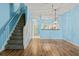 Open living space with sleek wood floors, staircase, pendant lighting, and open view to kitchen at 2314 Lake Woodberry Cir, Brandon, FL 33510