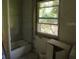 Bathroom with tiled walls, tub and window, ready to be personalized and renovated at 2355 Trelain S Dr, St Petersburg, FL 33712
