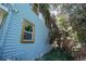 Two-story light blue home featuring traditional architecture with a lush, overgrown yard and window views at 2355 Trelain S Dr, St Petersburg, FL 33712