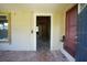 Living room featuring a front door view, window and partial covered porch and damaged flooring at 2355 Trelain S Dr, St Petersburg, FL 33712