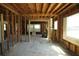 Living room view showcasing studs, unfinished walls, ceiling structure, and windows with wires on the ground at 2355 Trelain S Dr, St Petersburg, FL 33712