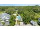Aerial view of community pool, homes, and a parking area amid lush trees at 290 Winchester Way, Palm Harbor, FL 34684