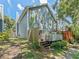 Exterior of a blue home with a wooden deck and partially fenced backyard at 290 Winchester Way, Palm Harbor, FL 34684