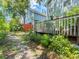 Exterior backyard with a wooden deck and a lush green garden at 290 Winchester Way, Palm Harbor, FL 34684