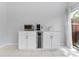 Bar area with mini fridge and countertop appliances with tile flooring and view to the outside at 290 Winchester Way, Palm Harbor, FL 34684
