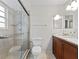 Modern bathroom with tiled shower, granite vanity, and well-lit mirror at 290 Winchester Way, Palm Harbor, FL 34684