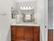 Bathroom featuring a granite vanity with ample storage and a large mirror and view of the shower at 290 Winchester Way, Palm Harbor, FL 34684