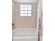 Classic bath features shower-tub combination with floral curtain and tiled walls at 290 Winchester Way, Palm Harbor, FL 34684