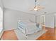 Bedroom featuring hardwood floors, neutral paint, ceiling fan and view of the bathroom at 290 Winchester Way, Palm Harbor, FL 34684