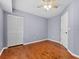 This bedroom features hardwood floors, neutral paint, and a closet for storage at 290 Winchester Way, Palm Harbor, FL 34684