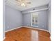 This bedroom features hardwood floors, neutral paint, a ceiling fan and a window for natural light at 290 Winchester Way, Palm Harbor, FL 34684