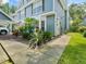 Charming blue townhome exterior with lush landscaping and sidewalk at 290 Winchester Way, Palm Harbor, FL 34684
