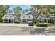 Exterior view of a blue townhome community with covered parking and mature trees at 290 Winchester Way, Palm Harbor, FL 34684