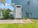 Exterior view of home's white front door with sidelight and neatly kept yard at 290 Winchester Way, Palm Harbor, FL 34684