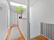 Hallway featuring hardwood floors, a skylight, and a modern plant adding natural light at 290 Winchester Way, Palm Harbor, FL 34684