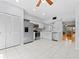 Updated kitchen with stainless steel appliances, white cabinetry and tile flooring, and view of the dining room at 290 Winchester Way, Palm Harbor, FL 34684