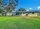 Backyard view showcasing the home's exterior, screened-in patio, and manicured lawn at 31096 Inwood Cir, Brooksville, FL 34602
