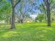 Lush backyard featuring a large, well-maintained lawn and mature trees at 31096 Inwood Cir, Brooksville, FL 34602