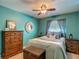 Charming bedroom features a ceiling fan, a large window with curtains, and a queen bed at 31096 Inwood Cir, Brooksville, FL 34602